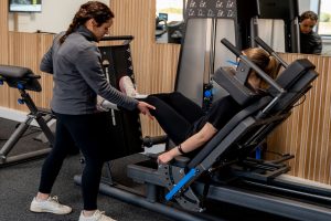 Patientin beim Kraftaufbau während der Knie-Rehabilitation in der Physiotherapie